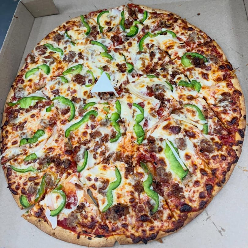 Hampton Hill Pizza's large pizza with green peppers, sausage, and onions in a box.