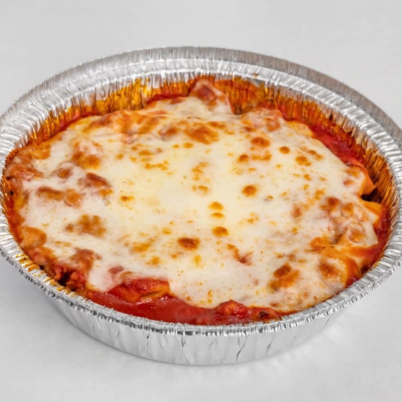 Baked ziti with melted cheese and tomato sauce in a foil container from Hampton Hill Pizza.