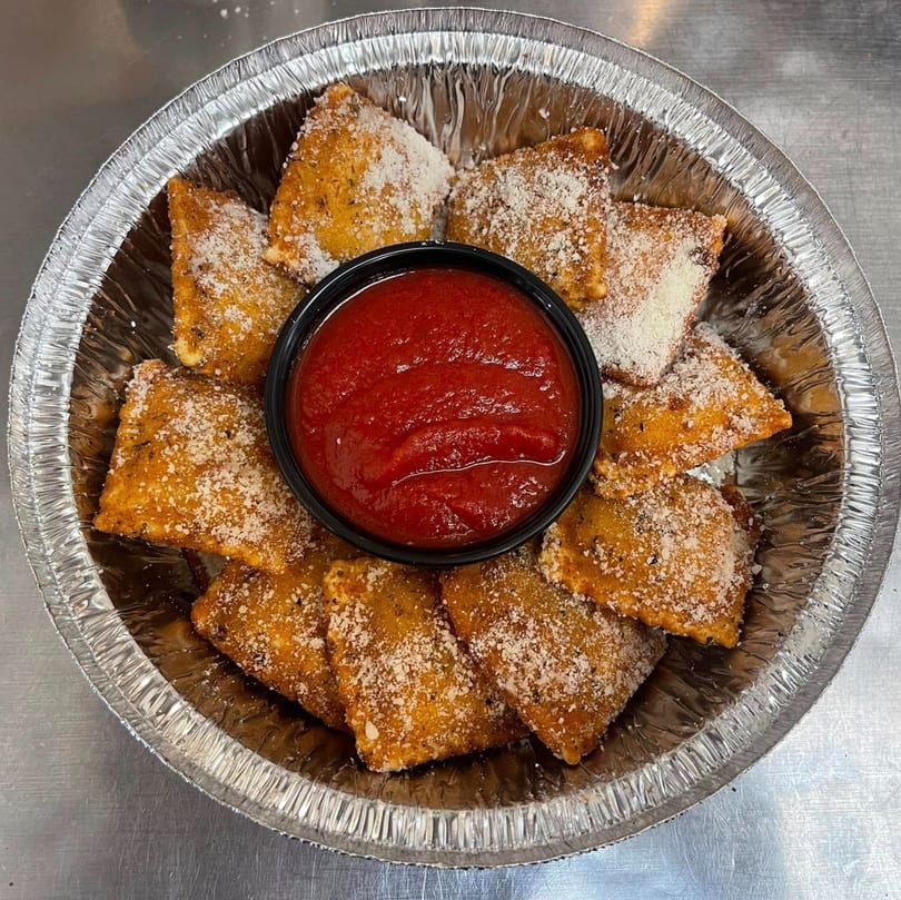 Hampton Hill Pizza's toasted ravioli, sprinkled with Parmesan cheese, served with a side of marinara sauce.